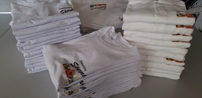 Stapel weißer Arbeitsshirts mit bedrucktem Firmenlogo