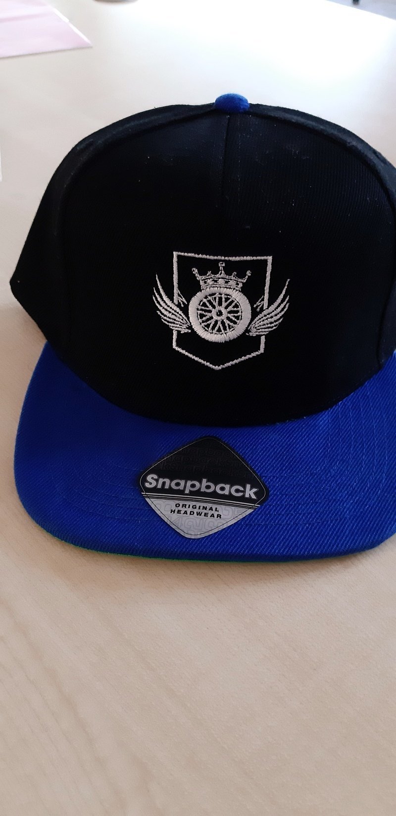 Schwarz-blaue Snapback-Cap mit silbern gesticktem Wappen
